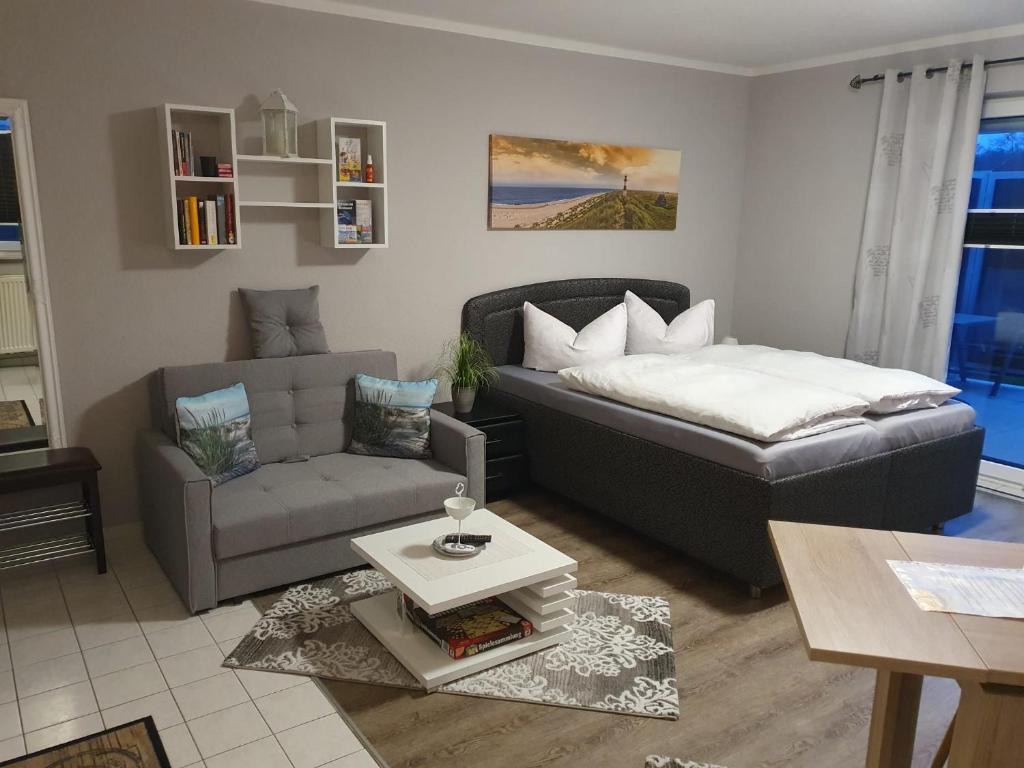 een woonkamer met een bank, een bed en een stoel bij Ferienwohnung Luna in Stralsund