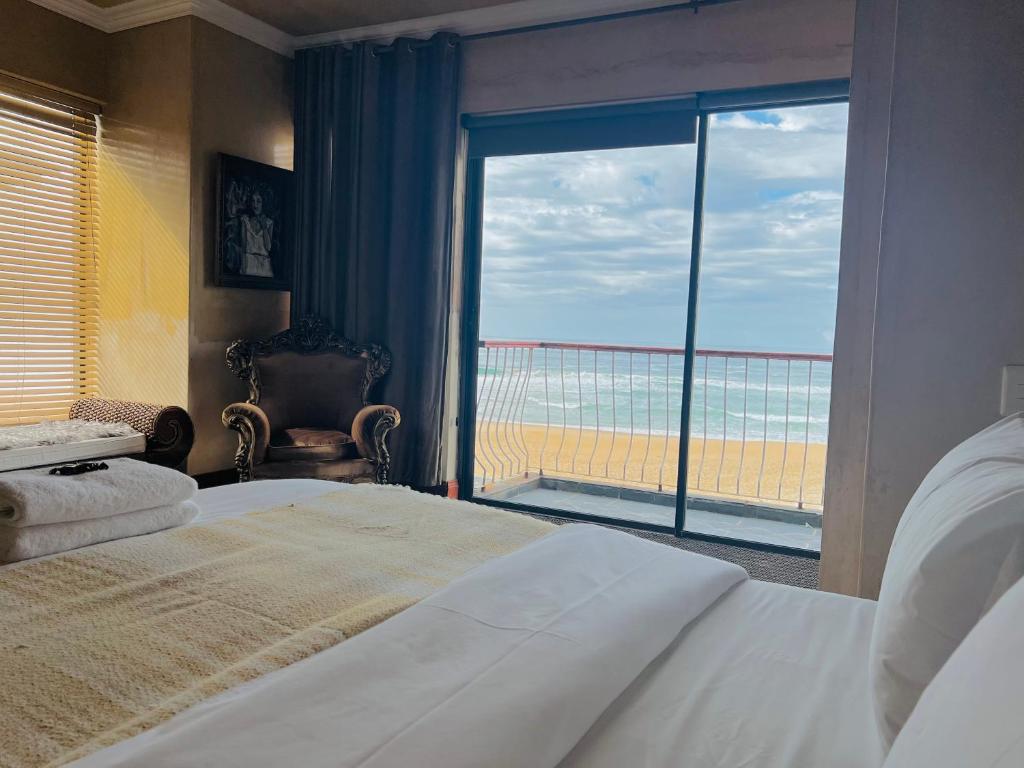 een slaapkamer met een bed en uitzicht op het strand bij Beachfront House in Groot Brak Rivier