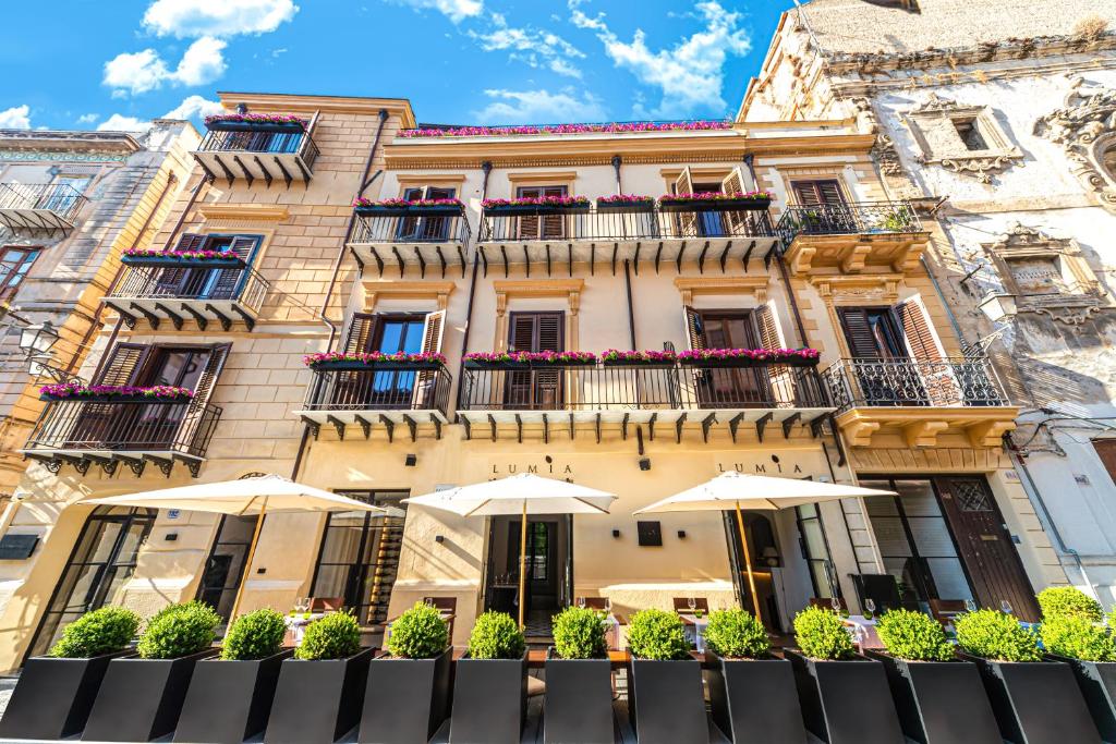 Casa Nostra Luxury Suites & Spa في باليرمو: مبنى فيه مظلات امامه