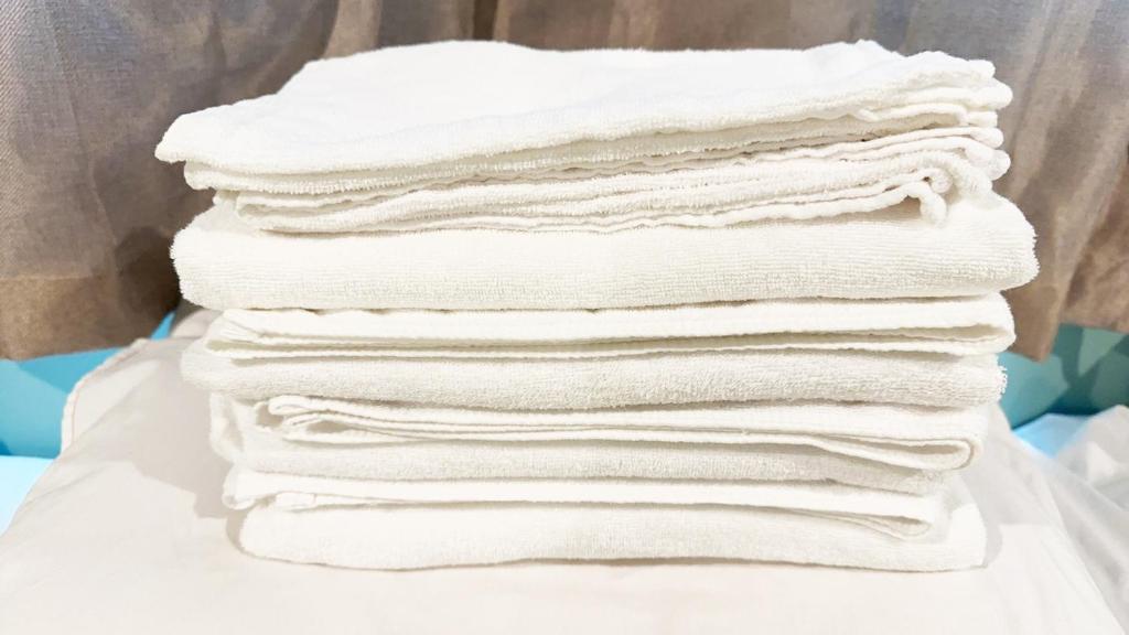 ein Stapel weißer Handtücher, übereinander gestapelt in der Unterkunft Hananogo Ikebukuro - Vacation STAY 09224v in Tokio