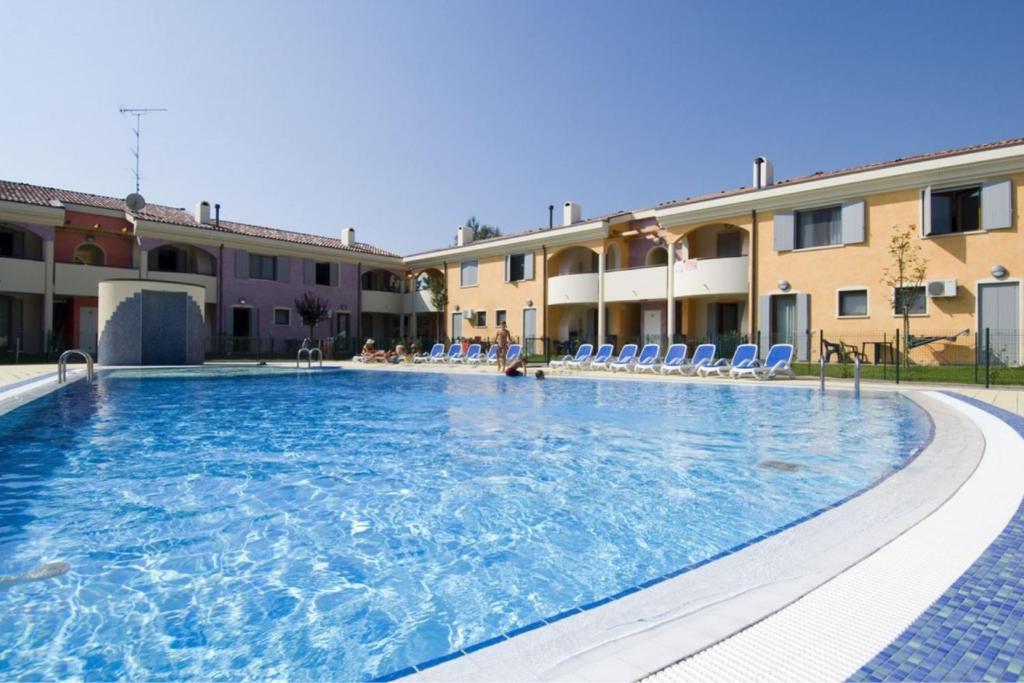einem großen Pool vor einem Gebäude in der Unterkunft Lovely holiday home with fenced garden and pool in Bibione