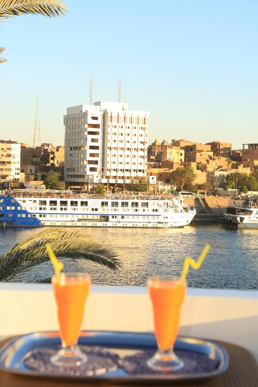 twee glazen sinaasappelsap op een dienblad op een tafel bij Crystala guest house in Aswan