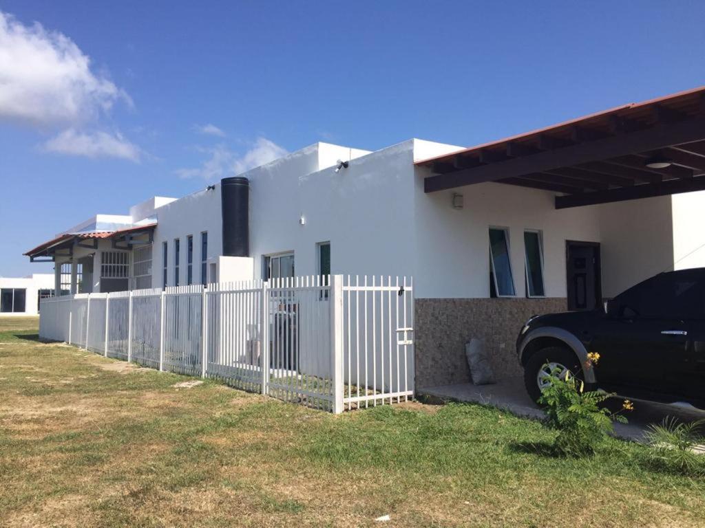 a black truck parked in front of a white house at MM VILLAGE in Río Hato