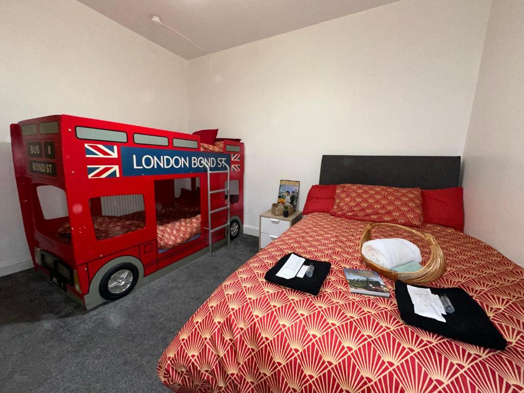 a bedroom with a red bed and a red bus at Station Signature Apartment near Lanark in Carstairs