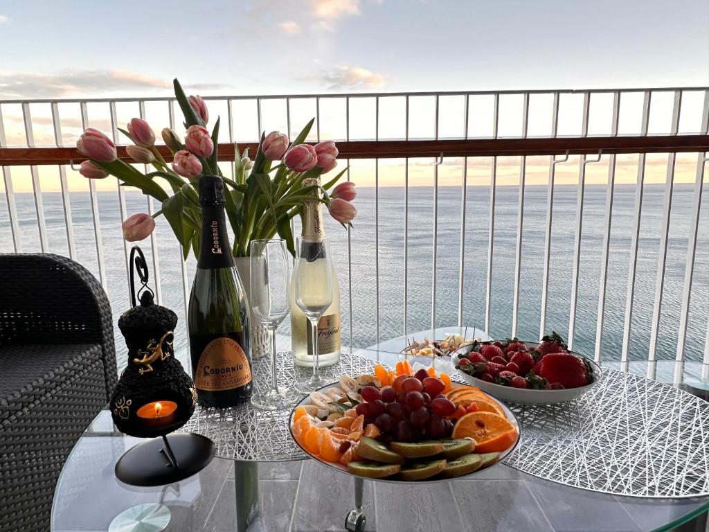 een tafel met een fruitschaal en een fles wijn bij Excellent view Julia in Alicante