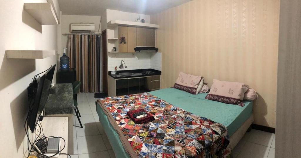 Cette petite chambre comprend un lit et une cuisine. dans l'établissement Megaroom Cinere Resort Apartment, à Gandul