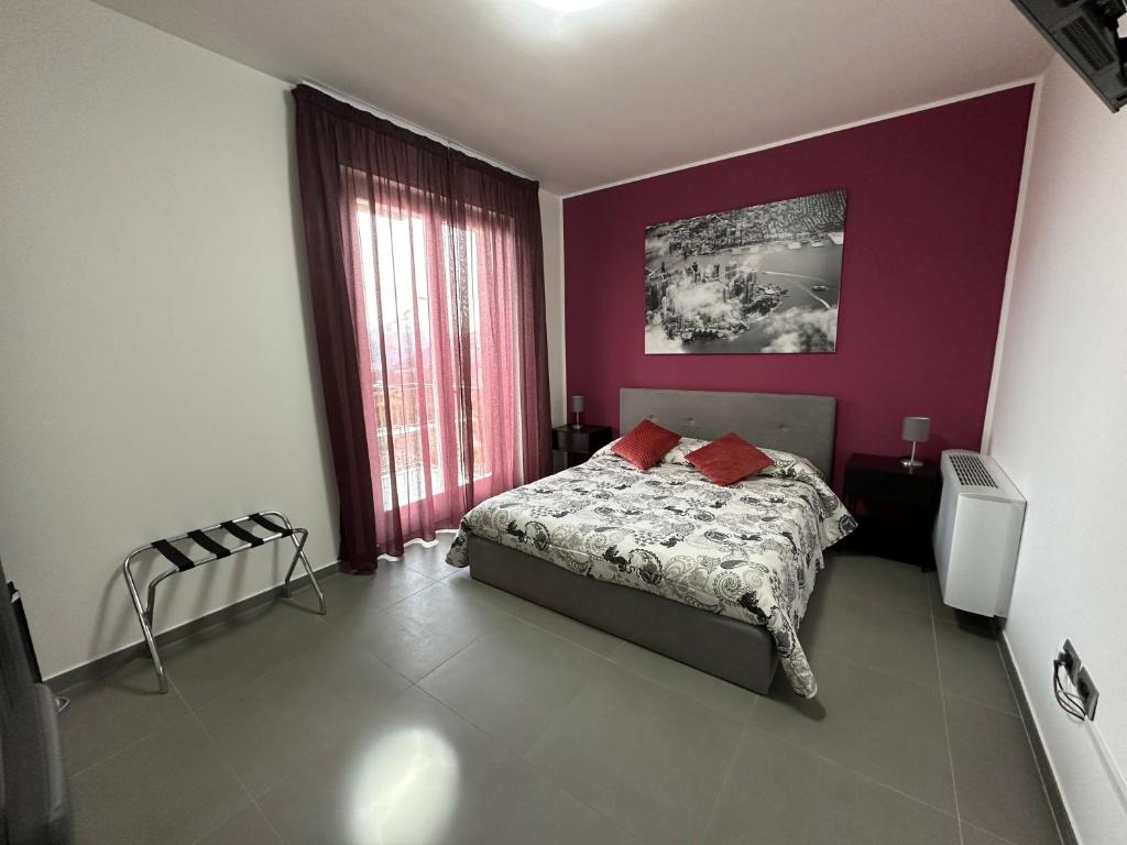 a bedroom with a bed and a purple wall at Lotelito Apartment in Fisciano