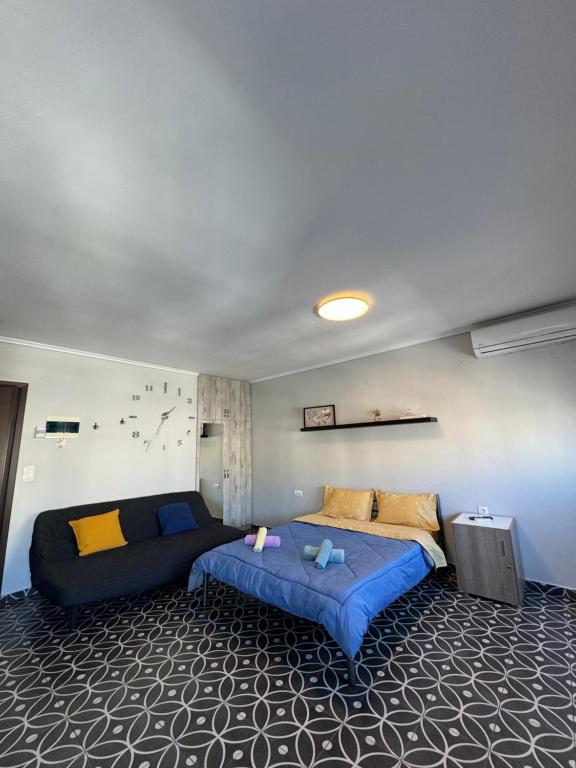 een slaapkamer met een bed en een bank erin bij Modiano Studio Ι By Socrates Junior Houses in Thessaloniki