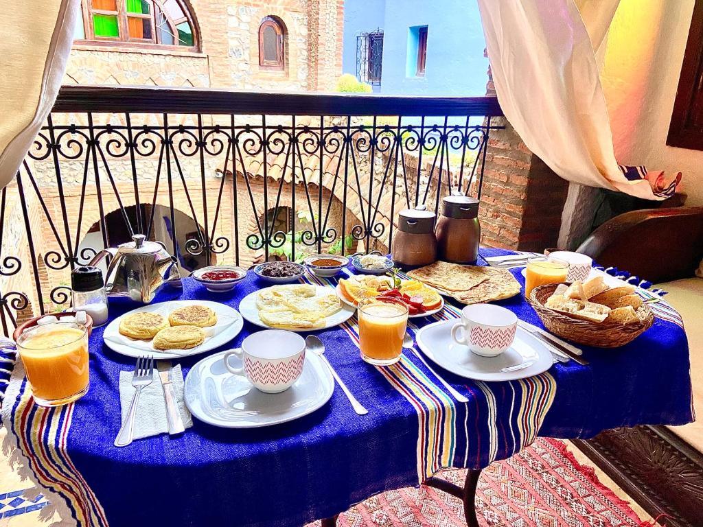 una mesa azul con comida para el desayuno y bebidas en ella en Riad Gharnata, en Chefchaouen