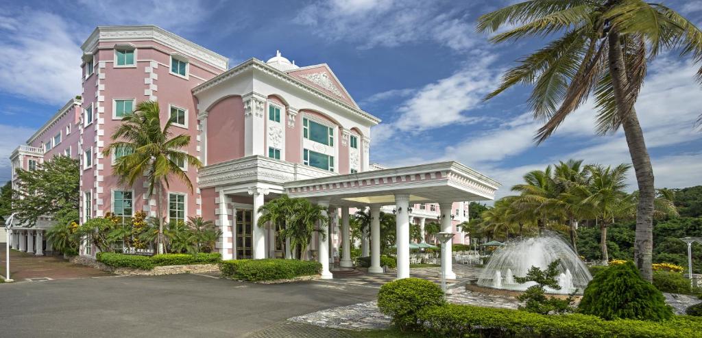 a pink building with a fountain in front of it at Le Beau Max Resort in Fanlu
