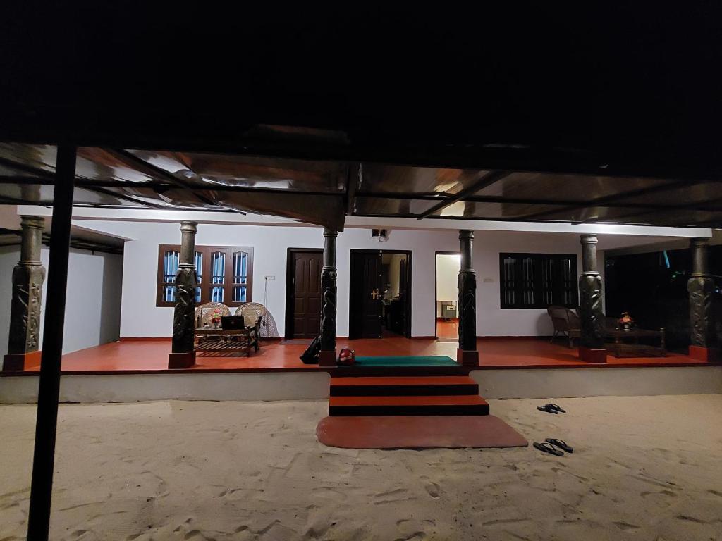 a living room with a staircase in a house at Marari Beach Homestay in Mararikulam