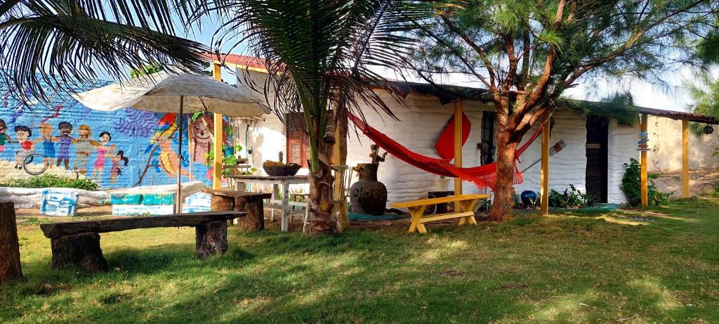 uma casa com uma mesa de piquenique e um guarda-chuva em chalé na praia da Taiba em São Gonçalo do Amarante