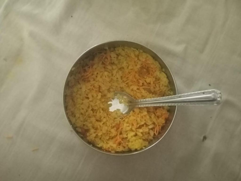 a bowl of rice with a spoon in it at Laxmi home stay in Ghūra