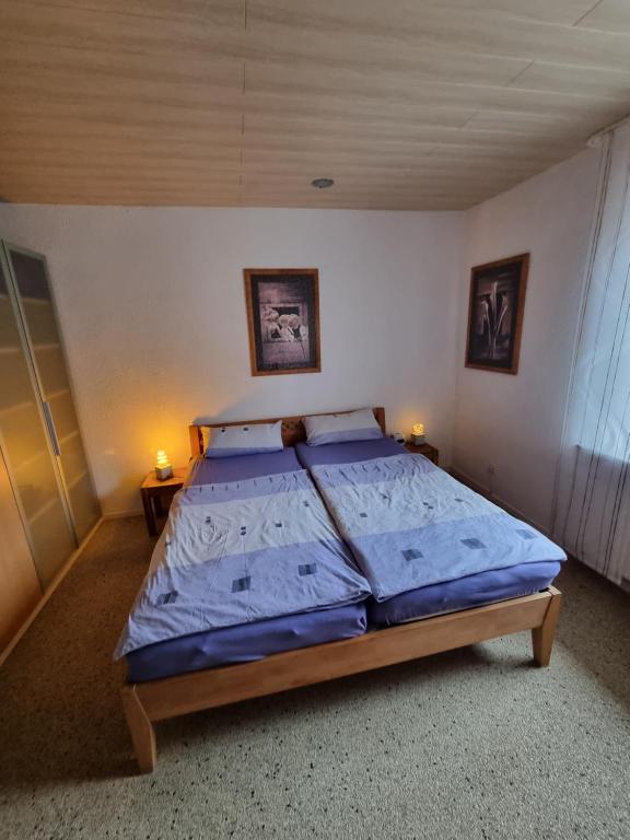 a bedroom with a bed with blue sheets and two lamps at Schnuckelige Wohnung in Marl