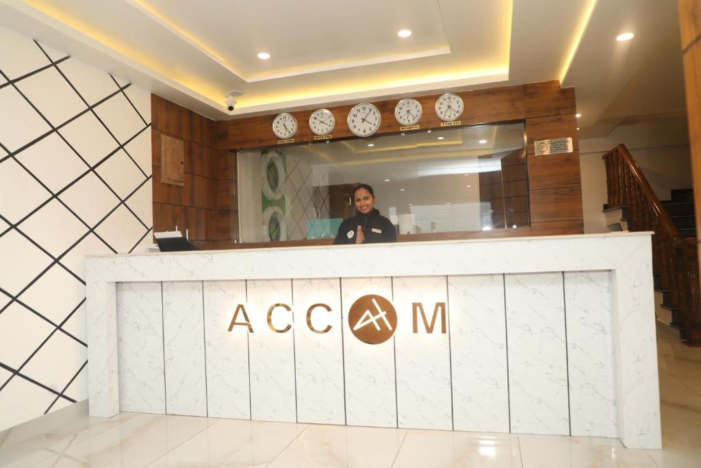 a woman standing behind a counter in a lobby at Accom Hotel in Ilām