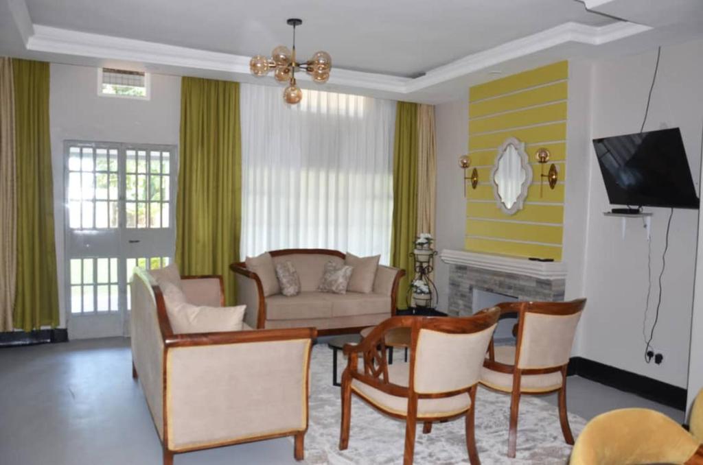 uma sala de estar com um sofá e uma mesa em RX Suites em Arua