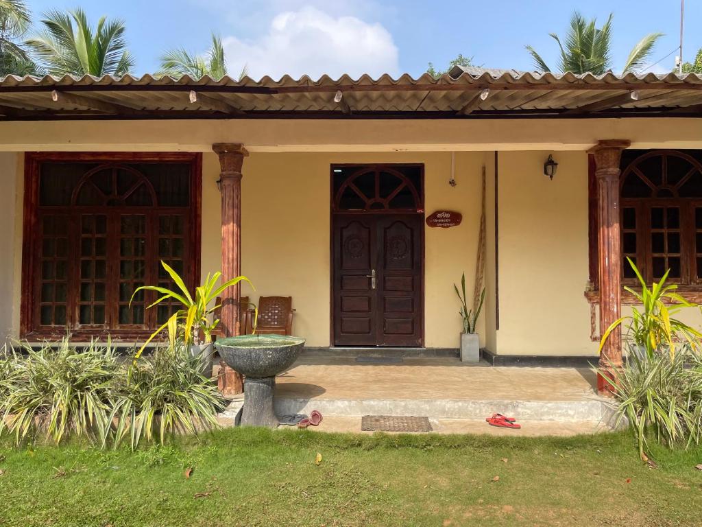 uma casa com uma porta da frente e uma fonte em Bhawana Canal View Resort em Nochchiyagama