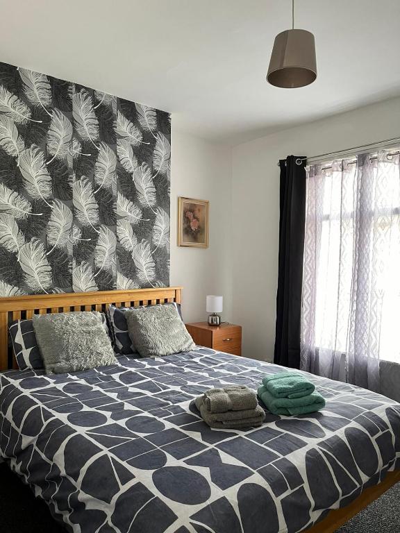 a bedroom with a bed with a blue and white comforter at House 36 in Liverpool