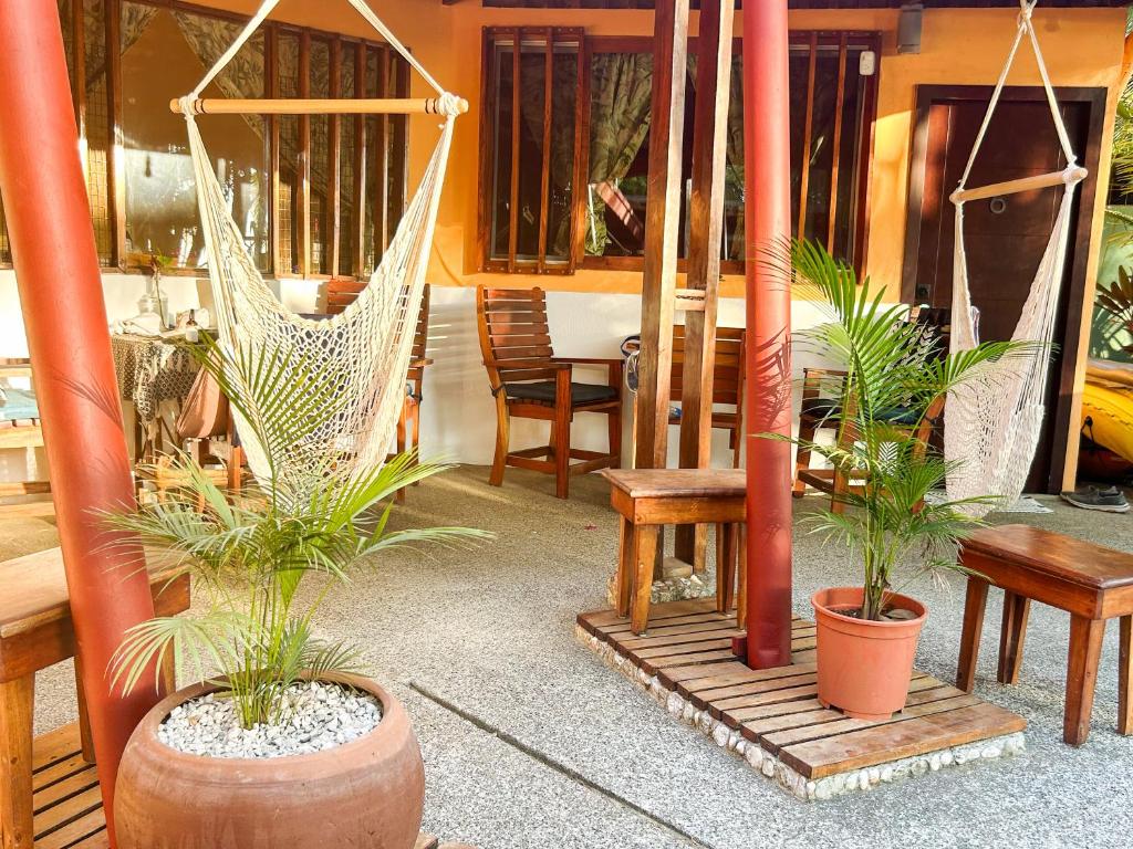 d'une terrasse avec un hamac, une table et des chaises. dans l'établissement Fenix Hotel - On the Beach, à Sámara