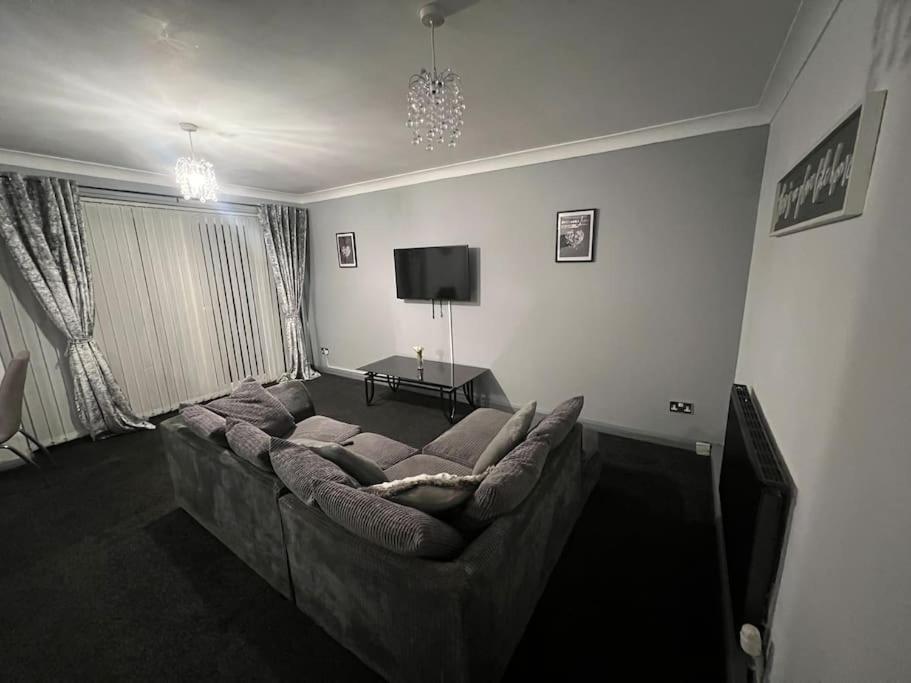 a living room with a couch and a tv at Washington Residence in Usworth