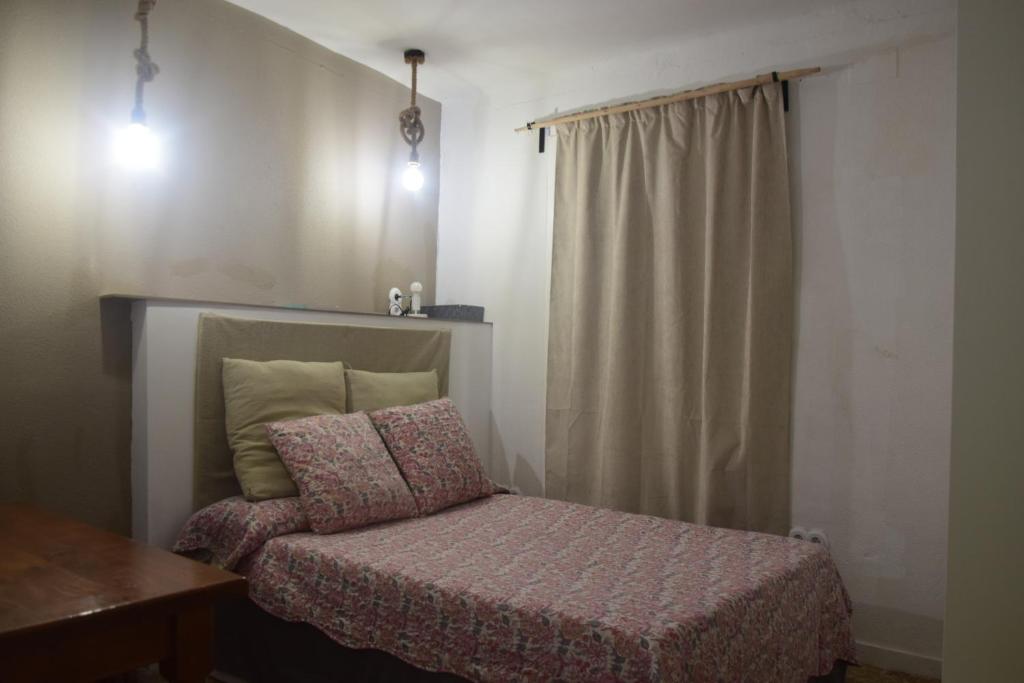 a small bedroom with a bed and a window at Habitación delante de la playa Blanes in Blanes