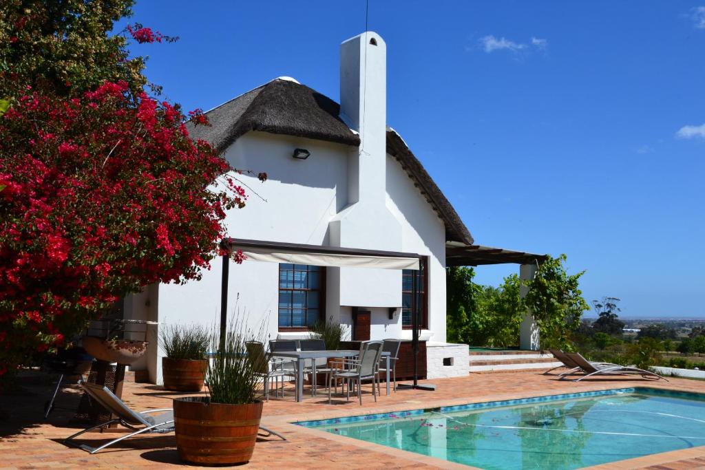 a villa with a swimming pool and a house at Saxenburg Wine Farm in Kuilsrivier