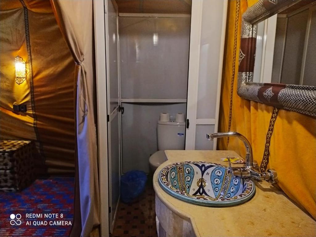 a bathroom with a sink and a toilet at Luxury Camp Camelhouse in Merzouga