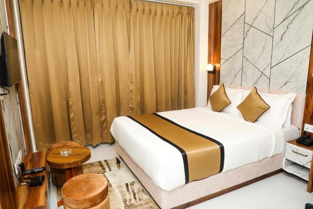 a hotel room with a bed and a television at Accom Hotel in Ilām