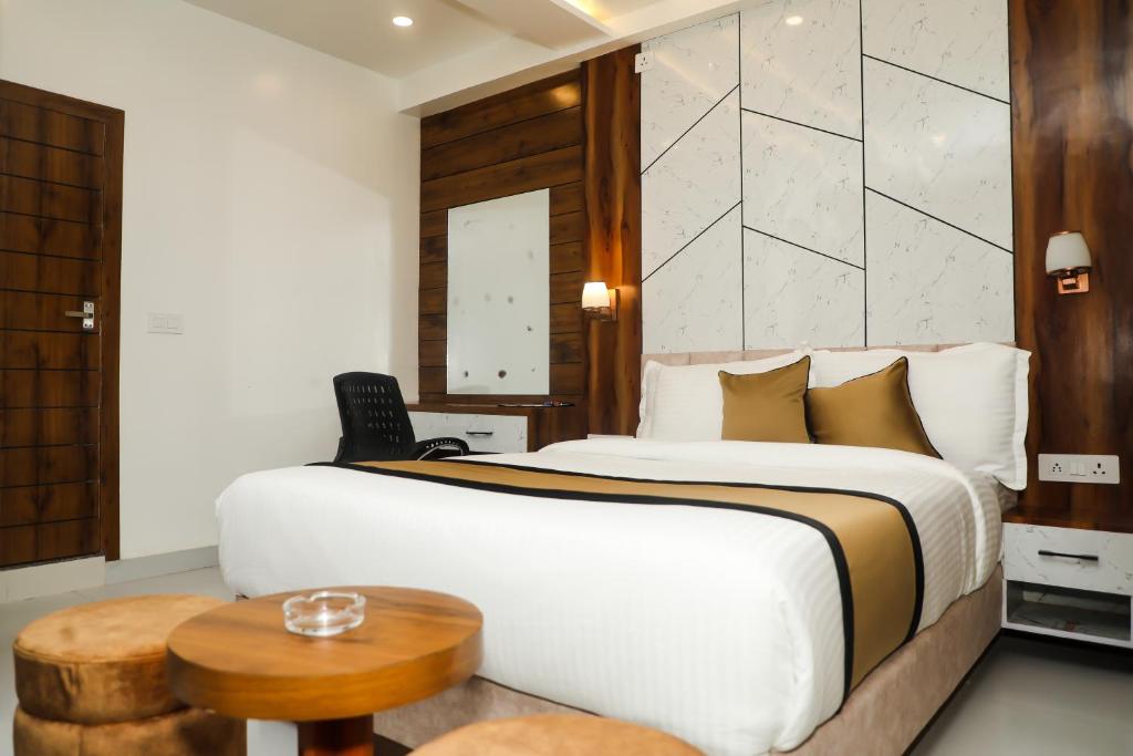 a bedroom with a large bed and a table at Accom Hotel in Ilām