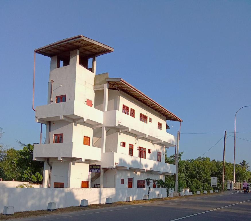 um edifício branco ao lado de uma rua em Villa Don Williams Weligama em Weligama