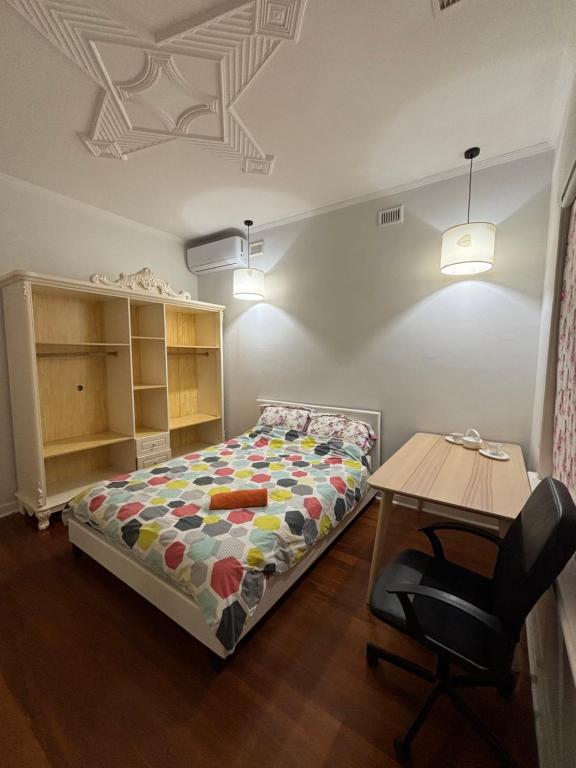 a bedroom with a bed and a table in it at Clarence Gardens in Colonel Light Gardens