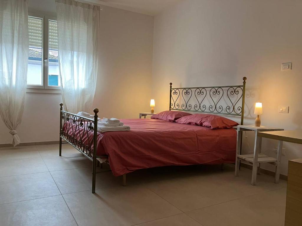 1 dormitorio con 1 cama grande con manta roja en MAISON ANZIO E ROSA, en Rávena