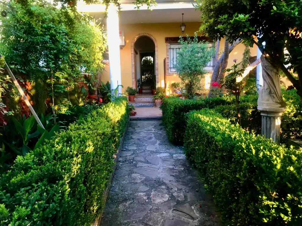 a walkway in front of a house with bushes at La Finca Mercedes in La Iruela