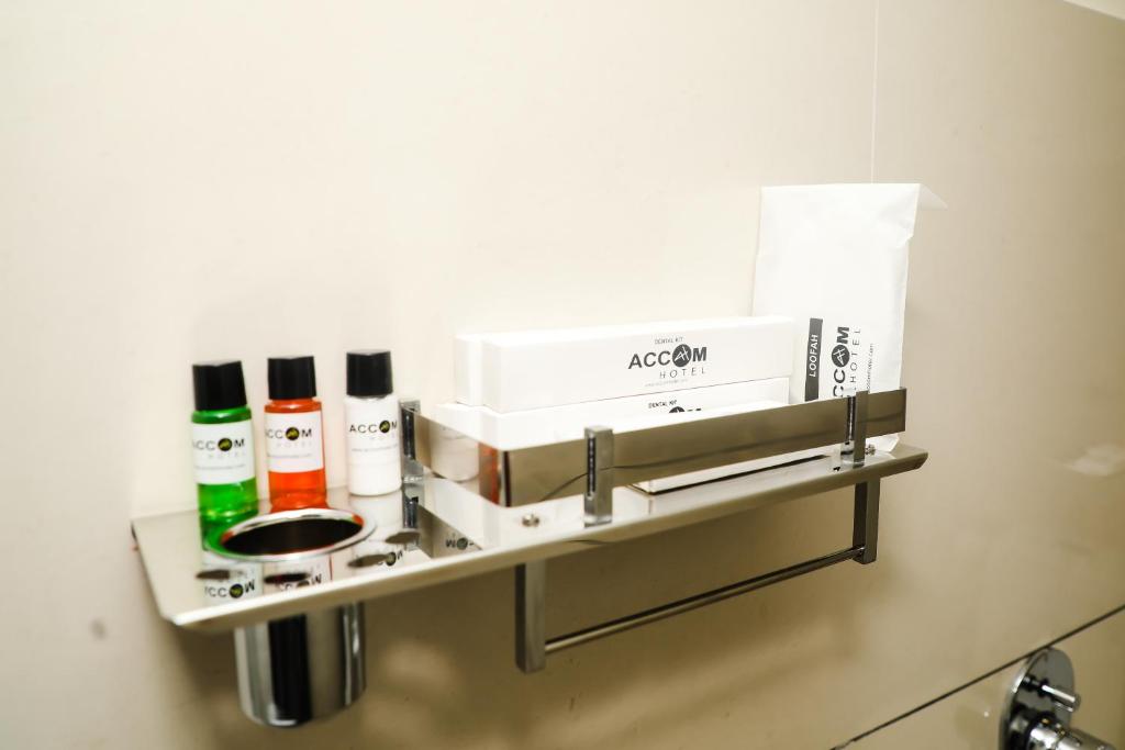 a shelf in a bathroom with products on it at Accom Hotel in Ilām