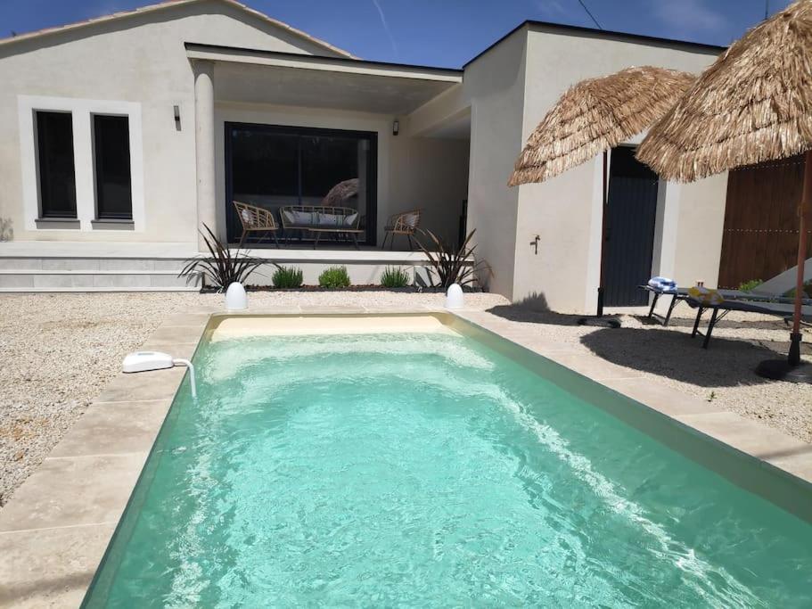 a swimming pool in front of a house at L'Orée des Alpilles Proche Centre ville St Rémy de Provence in Saint-Rémy-de-Provence