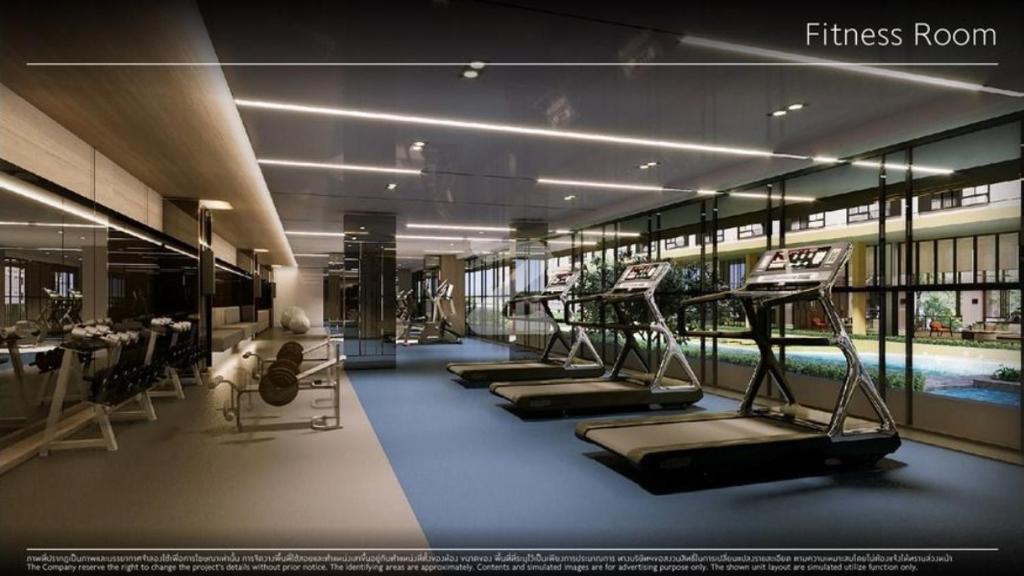 a fitness room with a row of treadmills and a pool at 1 Bed Room Near Saphanmai BTS, Don Mueang Airport in Ban Ko