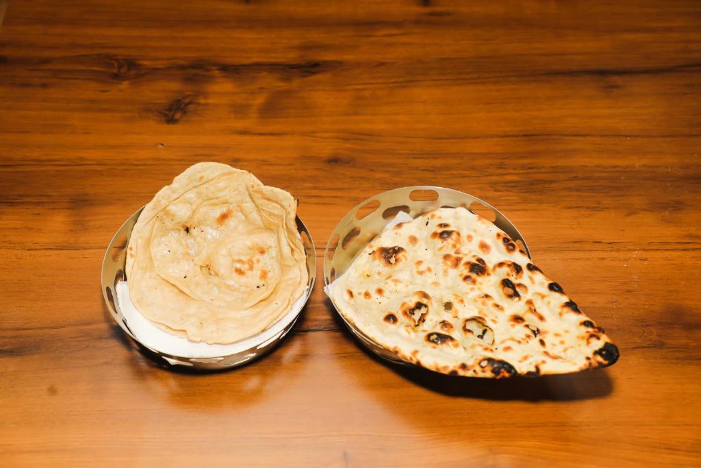 two food dishes with peanut butter on a wooden table at Accom Hotel in Ilām