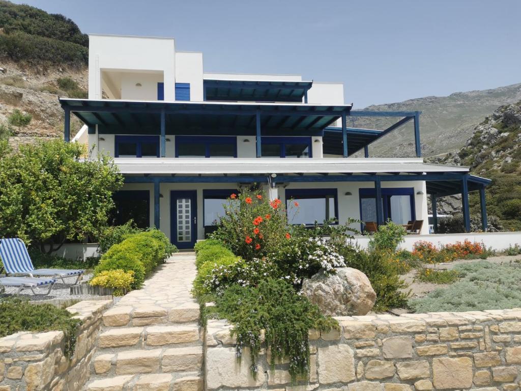 una casa en una colina con una pared de piedra en Konaki Apartments Kerames, en Kerames