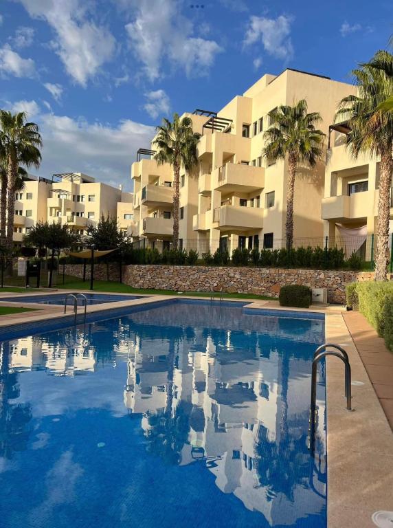 a swimming pool in front of a building with palm trees at Casa Cristina, Corvera in Corvera
