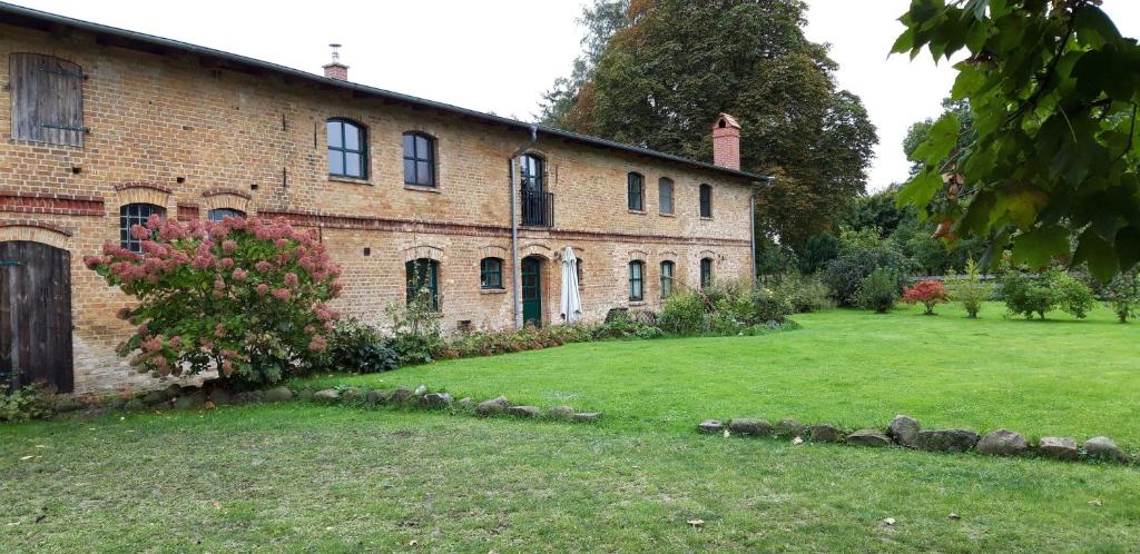 an old brick building with a yard in front of it at 75qm-grosse-Ferienwohnung-am-Naturschutzgebiet-15-PKW-Min-zum-Strand-Stettiner-Haff in Bugewitz