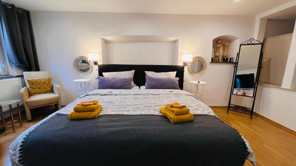 a bedroom with a large bed with yellow towels on it at Ferien am Schlössle in Ochsenfurt