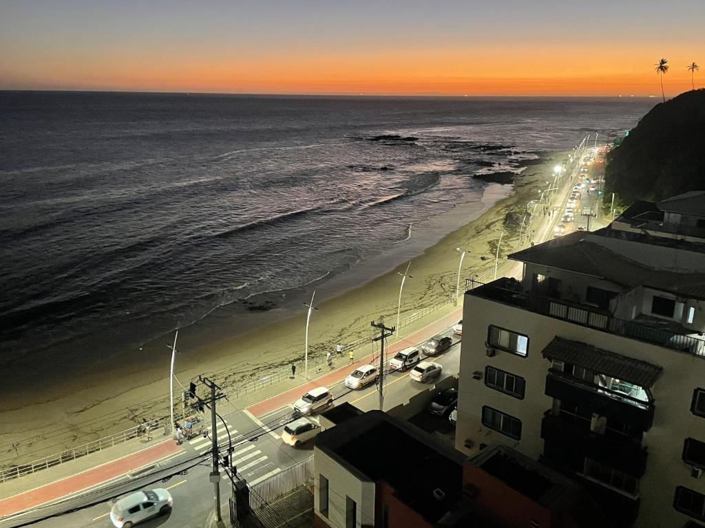 a view of a beach at sunset with cars parked at Casa da Geo Ondina - Frente de Praia in Salvador