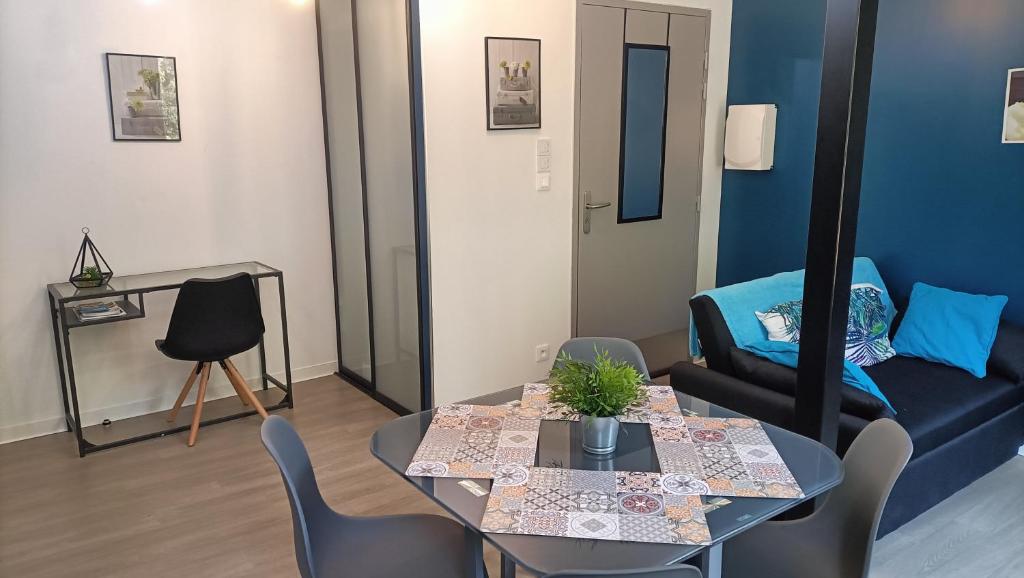 sala de estar con mesa y sofá en F1 duplex Bleuet Rénové, en Lamalou-les-Bains