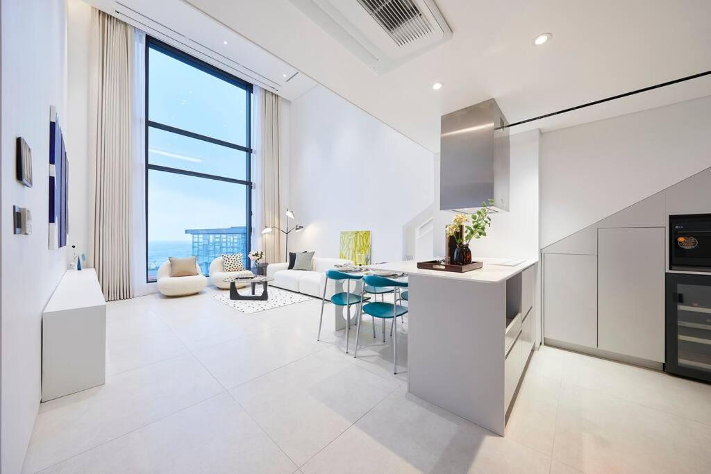 a white kitchen with a view of the ocean at B202 OceanView 돌고래출몰 수영장 노래방 스크린골프 in Seogwipo