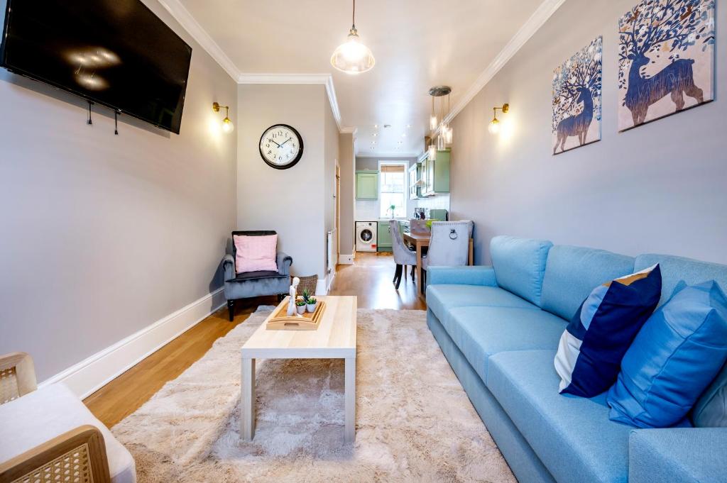 a living room with a blue couch and a table at Large 1 Bedroom in Center of London in London