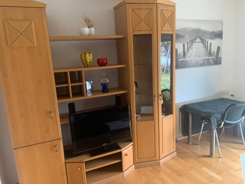 a living room with a entertainment center with a tv and a book shelf at Ferienappartment in Pliezhausen