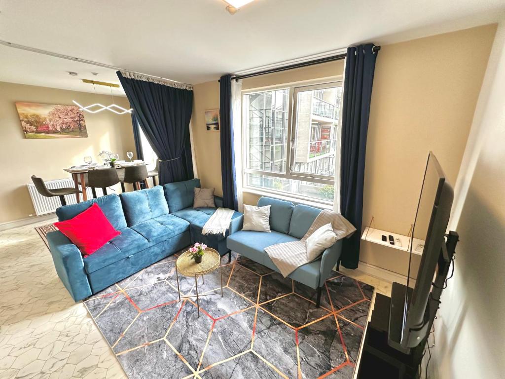 uma sala de estar com um sofá azul e uma televisão em Modern 2Bedroom Oasis near Dublin city centre & Airport em Dublin