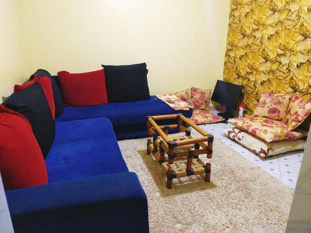 a living room with blue couches and chairs at Gill's Crib in Maseno