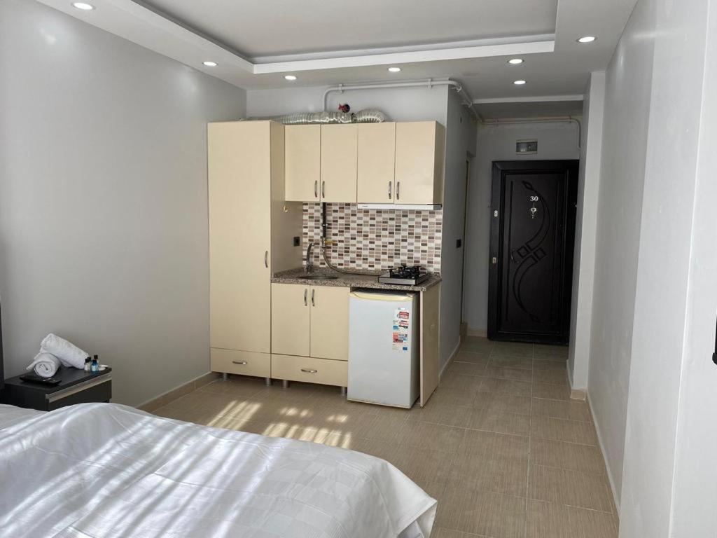 uma cozinha com armários brancos e um frigorífico branco em Hermes Otel em Edirne
