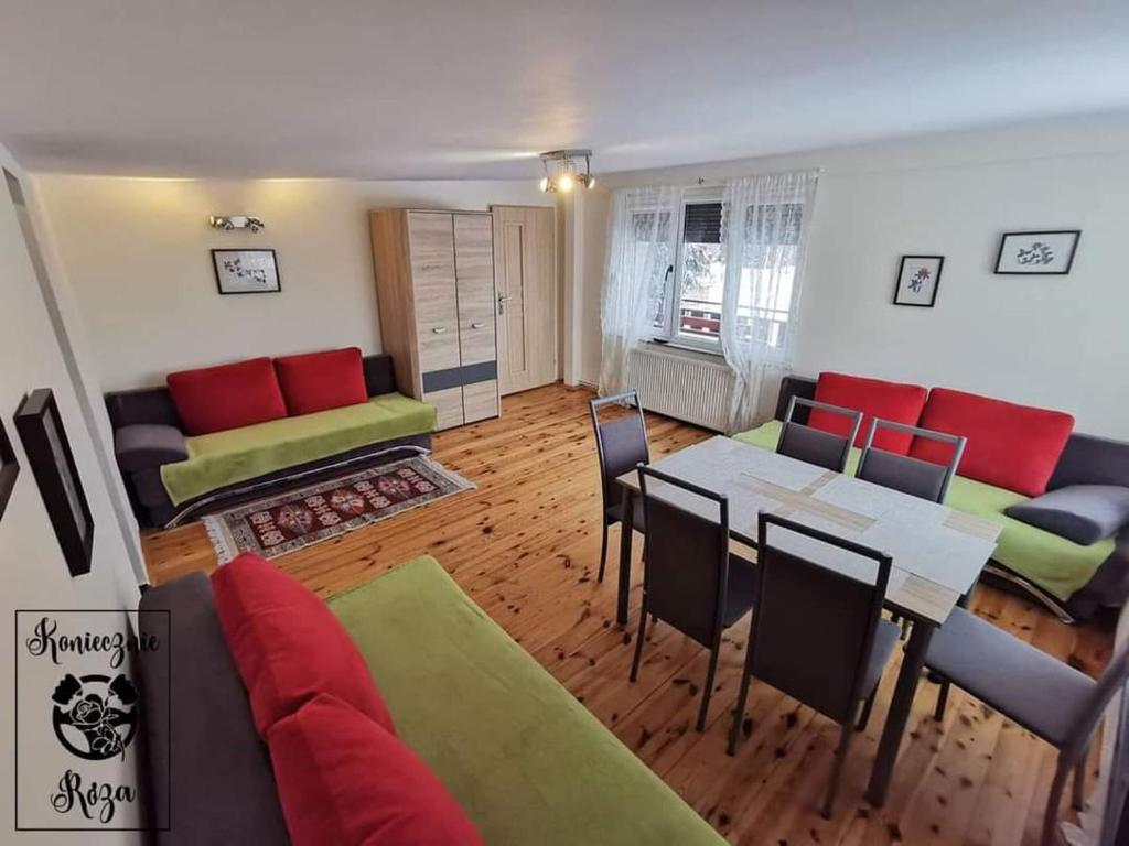 a living room with a couch and a table at Koniecznie Róża in Karpacz